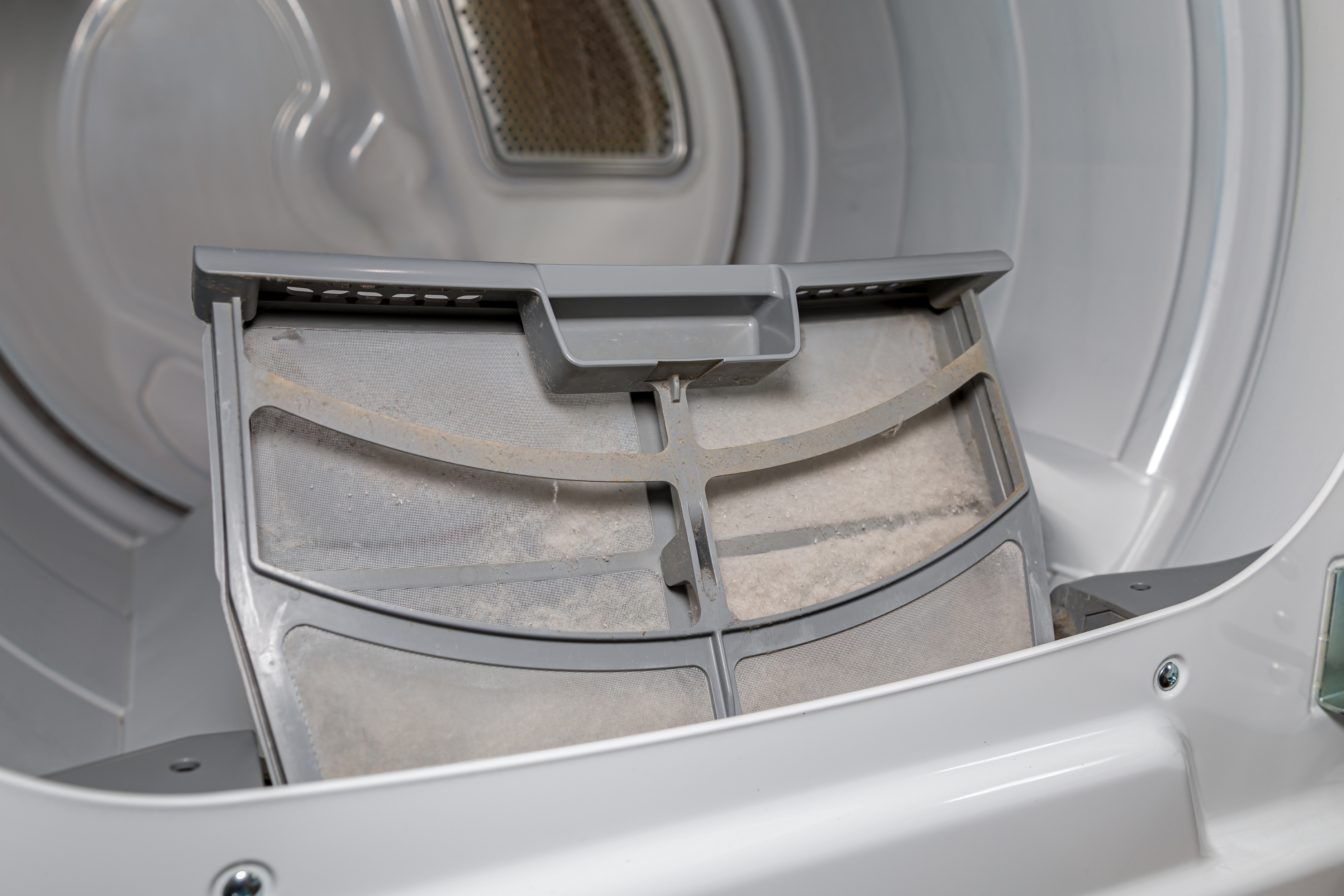 Interior sucio de una secadora, destacando el filtro que necesita limpieza para eliminar malos olores